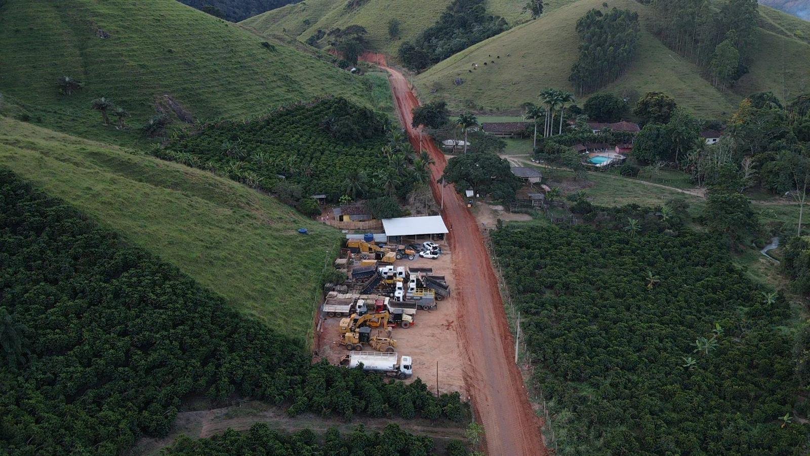 Vista aérea de canteiro da Escave com escavadeiras, motoniveladora e caminhões em obra de terraplenagem no interior do ES